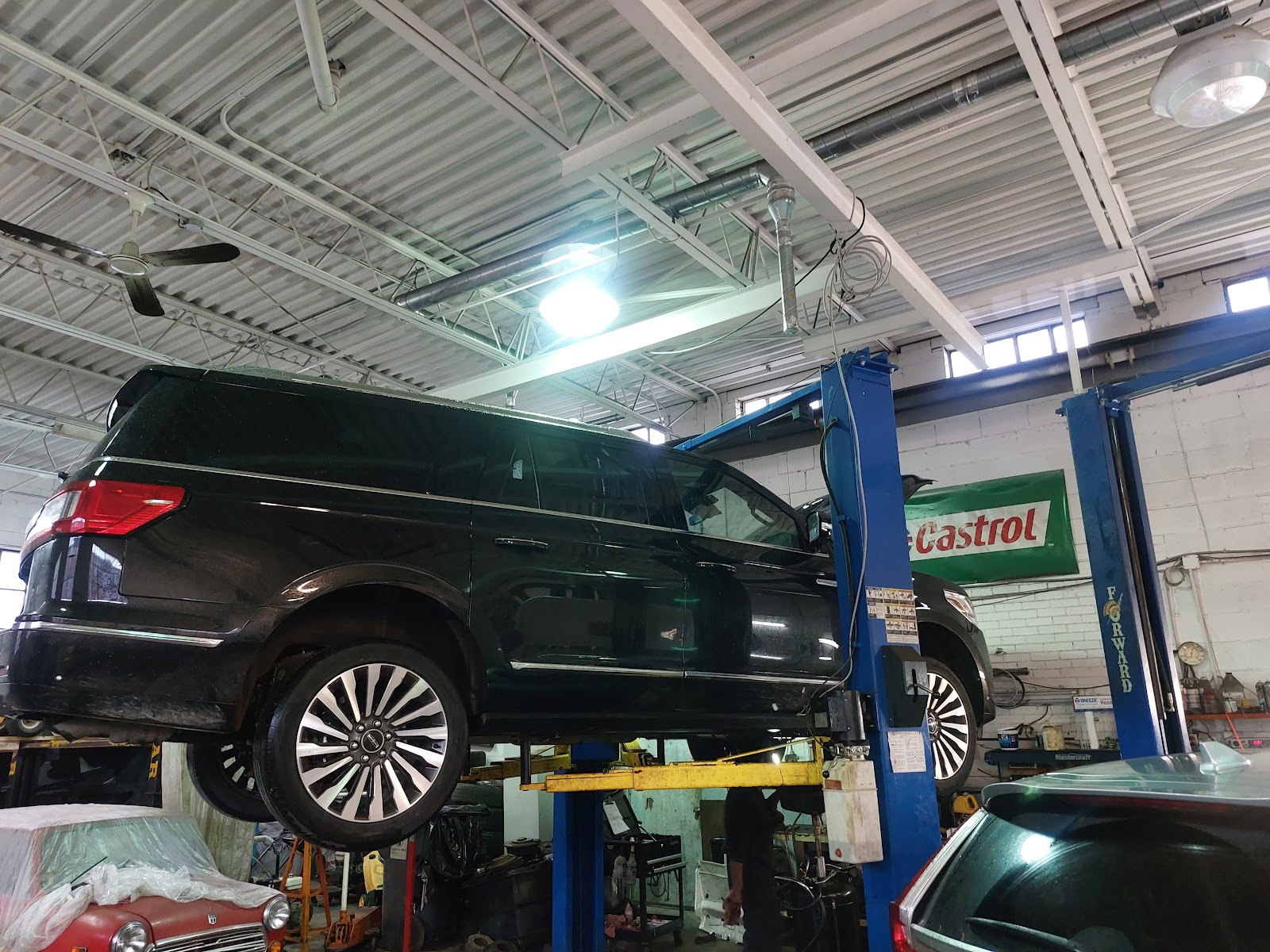 Vehicle on a two-post lift inside the Nainar Auto Service garage